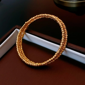 Detailed macro view of gold-plated multi-layer bangle with a sparkling textured finish