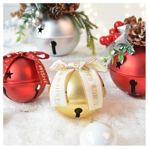 Close-up of decorative Christmas bells with festive ribbons and star cutouts on a tree