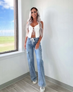 Detail of light blue high waist wide leg cargo jeans with large side pockets and drawstring