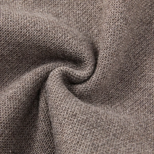 Close-up of soft brown-grey knitted fabric texture showing fine craftsmanship and draping