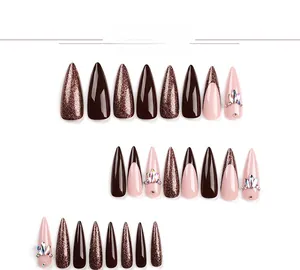 Detailed view of long stiletto press-on nails featuring brown glitter and rhinestone accents