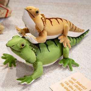 Plush bearded dragon stuffed animals in green and brown on a soft white rug