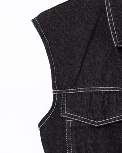 Detail of black denim fabric with white contrast stitching and pocket seams