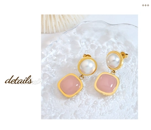 Detail of pink jade drop earrings with pearls and gold frame on a textured tray