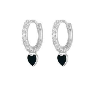 Detail of silver hoop earrings with black heart charms and sparkling zircon inlay
