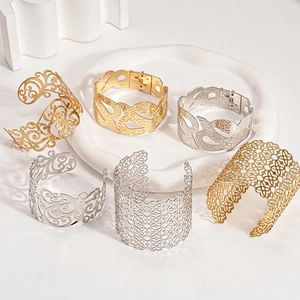 Eleganti bracciali rigidi traforati in oro e argento con motivi floreali e geometrici