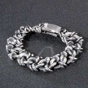 Close-up of bold interlocking silver steel chain links with rectangular snap clasp
