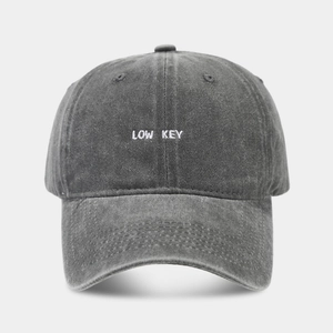 Dettaglio del ricamo LOW KEY sul berretto da baseball in cotone lavato grigio scuro