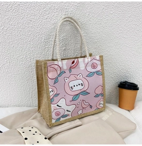 Detail of jute tote bag featuring peach and cat prints with cotton rope handles