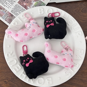 Detail of cute fabric cat plush keychains with embroidery on a decorative ceramic plate