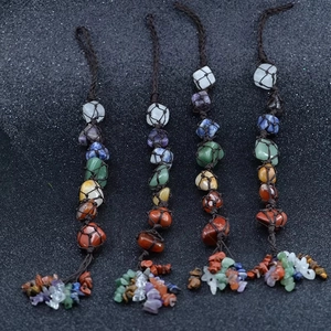 Detail of 7 chakra natural stones in handmade woven mesh pouches with crystal tassels