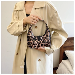 Detail of leopard print patent leather handbag with dual zippers and smooth finish