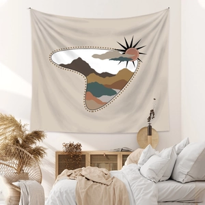 Detail of bohemian wall tapestry featuring minimalist sun and mountain landscape art
