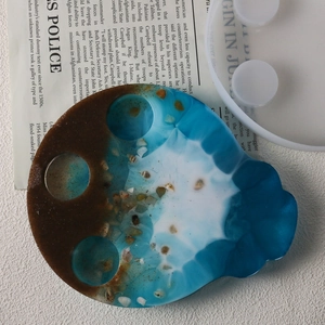 Detail van doe-het-zelf epoxyhars oceaanblad met echte schelpen en siliconenvorm
