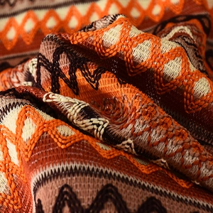 Gros plan du motif de vagues bohèmes orange sur le cardigan sans manches en maille de qualité