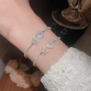 Detail of silver and gold heart star bracelets with cubic zirconia on a wrist