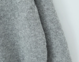 Close-up of soft grey knit fabric with plush mohair texture and fine wool fibers