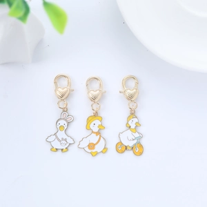 Three cute cartoon duck keychains featuring bunny ears, sun hat, and bicycle charms