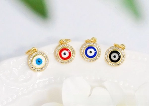 Detailed macro view of 18K gold plated evil eye charms with colorful enamel and cubic zirconia