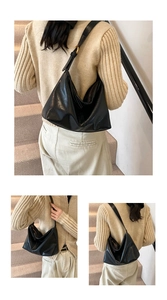 Detail of black large tote bag showing soft leather texture and adjustable gold buckle