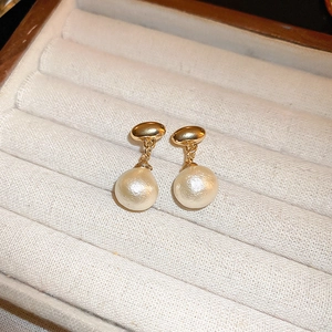 Vintage gold geometric stud earrings with baroque pearl drops in a jewelry box