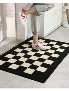 Close-up of checkerboard doormat texture with a model stepping on the plush surface