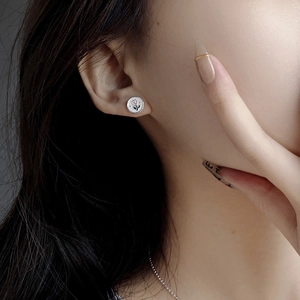 Close-up of S925 silver tulip stud earrings with pink enamel finish worn by a model