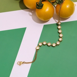 Detail of gold zircon tennis bracelet with lobster clasp on geometric background