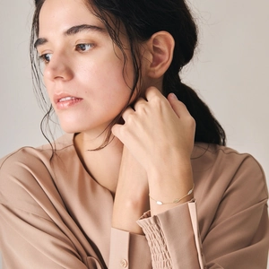 Detailed close-up of a delicate gold-plated 925 silver leaf bracelet on a model's wrist