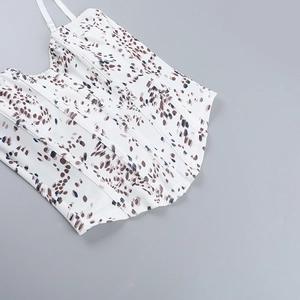 Flat lay of white floral camisole top with brown leopard print and thin shoulder straps