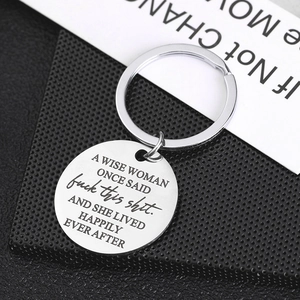 Inspirational stainless steel keychain with engraved quote on a sleek black surface