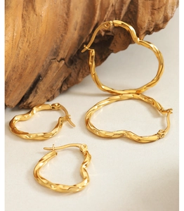 Detailed view of gold heart-shaped hoop earrings with unique twisted texture on stone