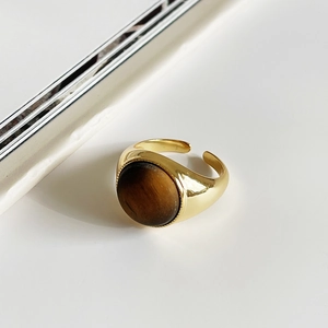 Macro shot of 925 silver golden ring with a large round tiger eye stone inlay
