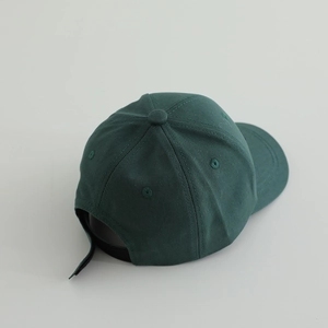 Detail of dark green cotton baseball cap with adjustable strap and breathable eyelets