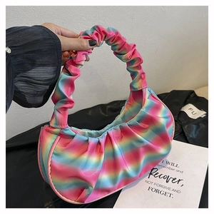 Detail of rainbow pleated cloud bag with vibrant pink, blue and yellow gradient textures