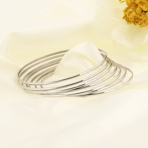 Minimalist stackable 18K silver-plated stainless steel round bangles set on silk background