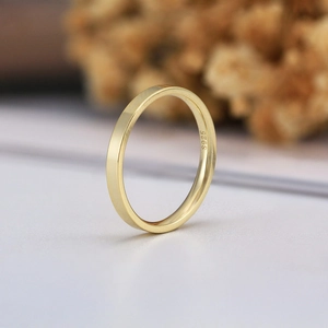 Anello minimalista da 2mm in argento sterling S925 placcato oro su sfondo professionale