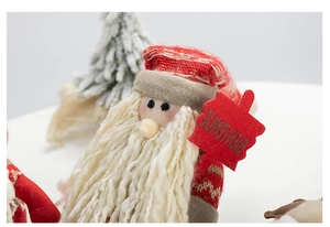 Close-up of Santa doll with knitted texture and Bienvenue sign for Christmas decor