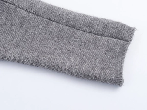 Detailed macro view of medium grey knit coat cuffs with soft wool-like texture and stitching
