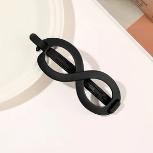 Macro detail of matte black infinity hair claw clip showing frosted texture and strong grip