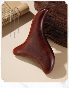 Macro shot of polished sandalwood triangular massager with natural wood grain texture