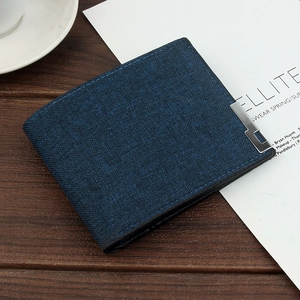 Detail of dark blue men's wallet with fiber texture and metal edge on wooden background