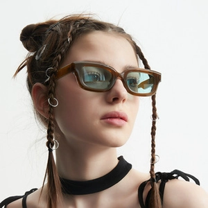 Close-up of retro amber frame sunglasses with light blue lenses on a model profile
