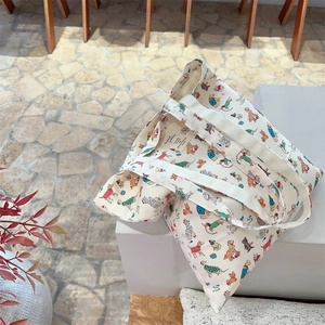 Close-up of a canvas tote bag with colorful cartoon dog prints on a white step