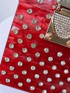 Red acrylic marbled evening clutch bag with sparkling rhinestones and gold metal clasp