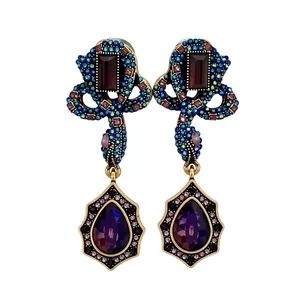 Vintage style antique gold drop earrings with purple teardrop crystals and emerald stones