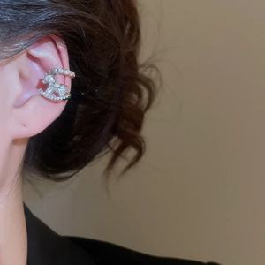 Detail of silver rocking horse ear cuff with sparkling zircons worn on ear