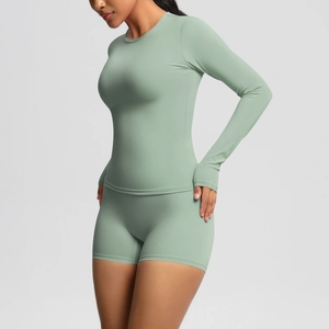 Detail of sage green yoga set showing long sleeve top and shorts with slim fit design