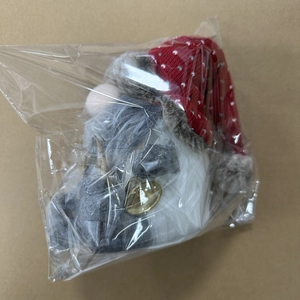 Detail eines Weihnachtsgnoms mit roter gepunkteter Mütze und goldener Glocke verpackt