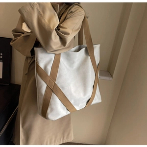 Detail of cross webbing design and reinforced stitching on durable canvas tote bag